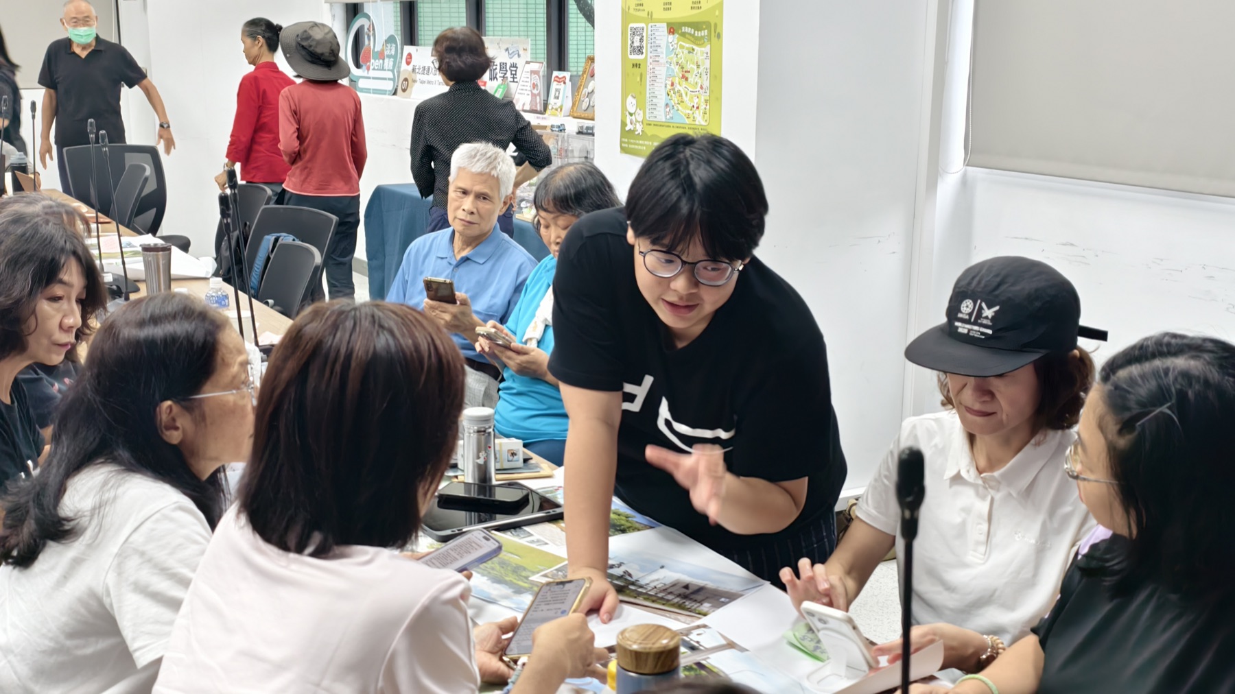 引導者俯身陪伴參與者完成手機文字與小組作品