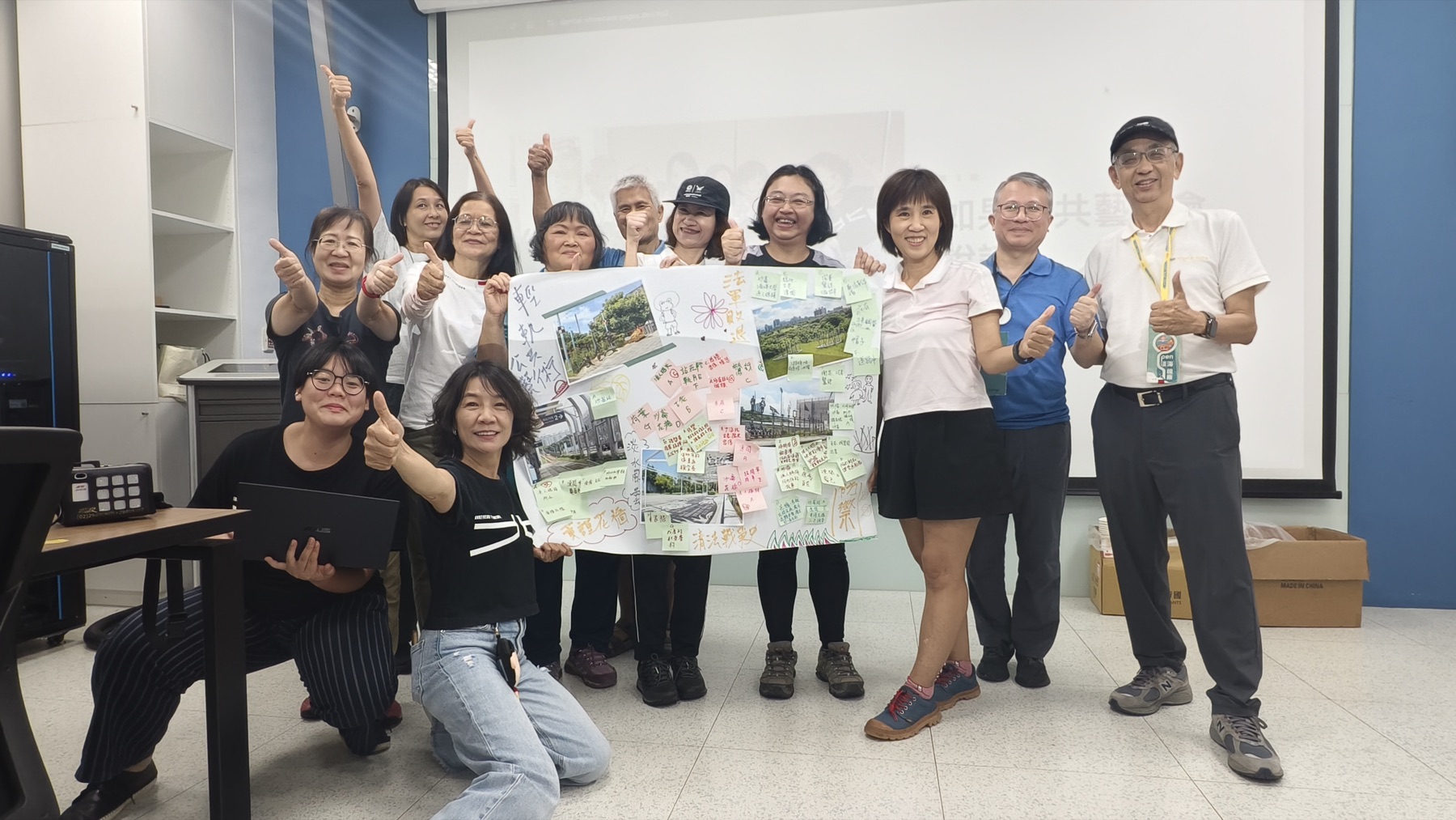 9月12日參與者與貼有站點照片、便條和手寫圖像的現場共創版圖合影